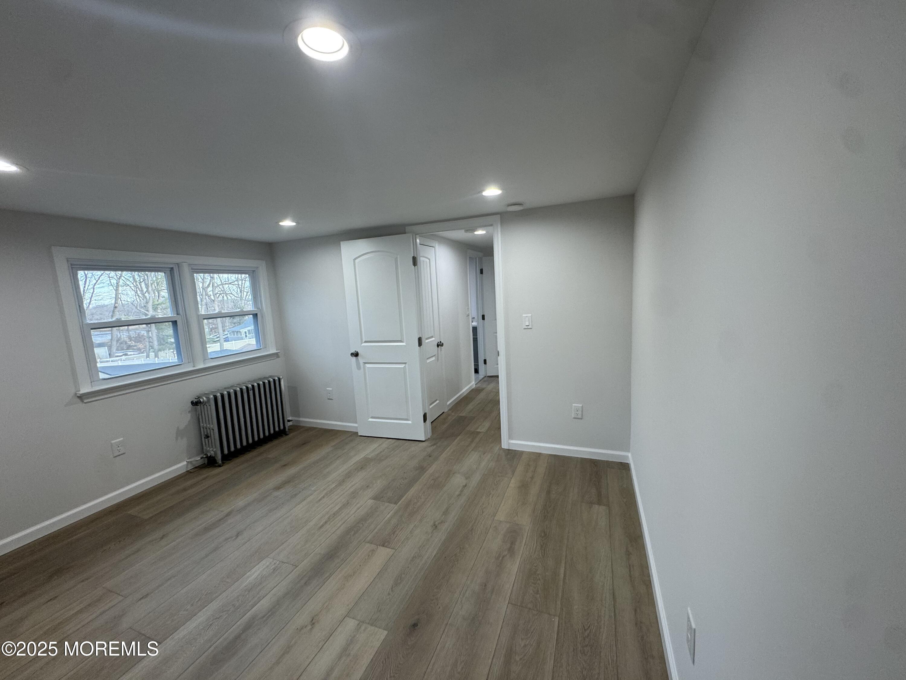 259 Matawan Avenue, Unit 2 Matawan, NJ 07747 - Photo 17 of 18 an empty room with wooden floor and windows