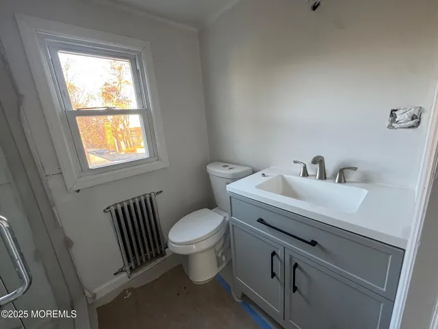 a bathroom with a sink toilet and window