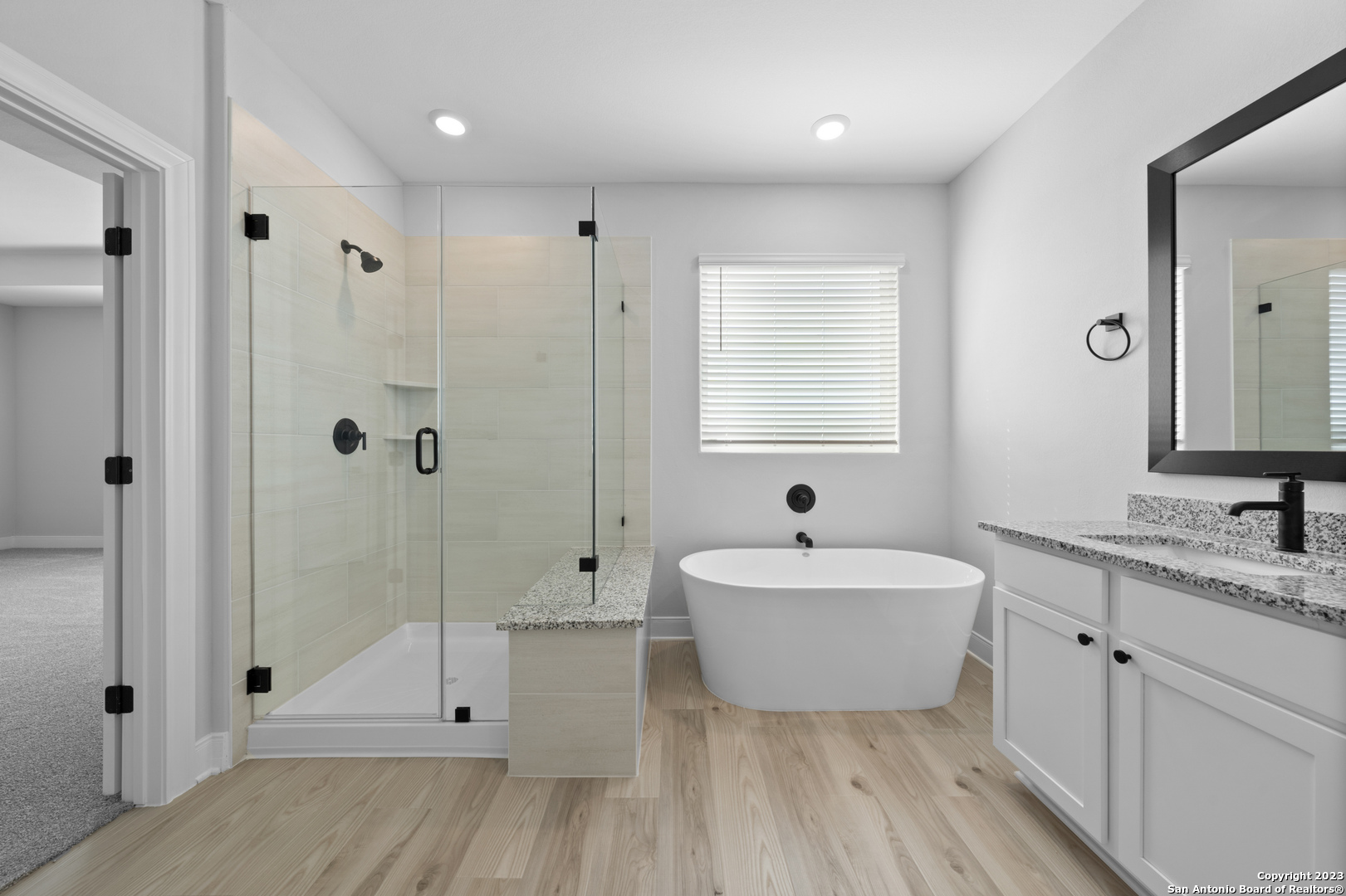 174 Azalea Alley Castroville, TX 78009 - Photo 13 of 22 a spacious bathroom with a double vanity sink a mirror and a bathtub