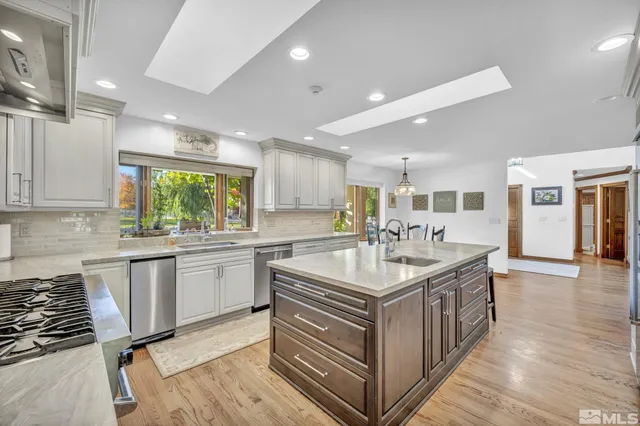 a large white kitchen with a sink and stove
