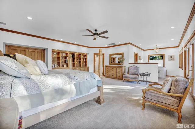 a spacious bedroom with a bed a couch and a chandelier