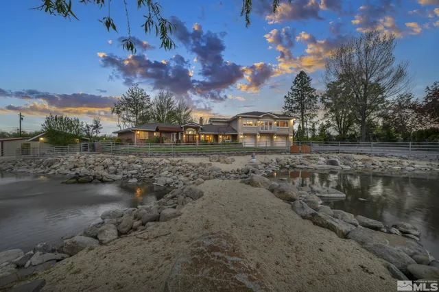 a view of a house with a yard and a large tree