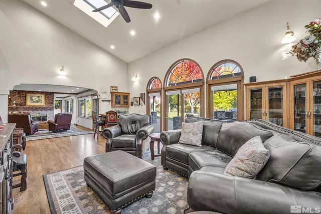 a living room with furniture ceiling fan and a large window