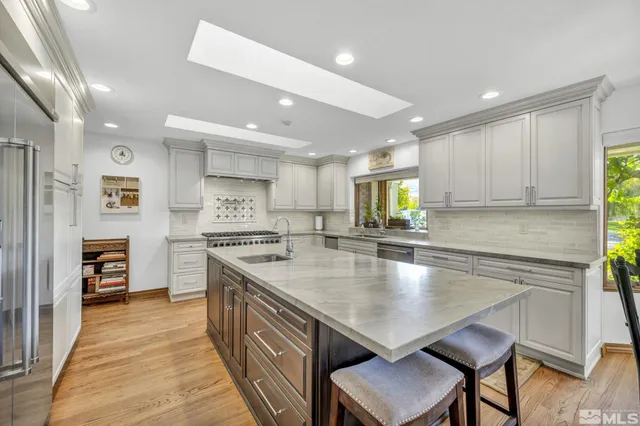 a large kitchen with stainless steel appliances a large counter top