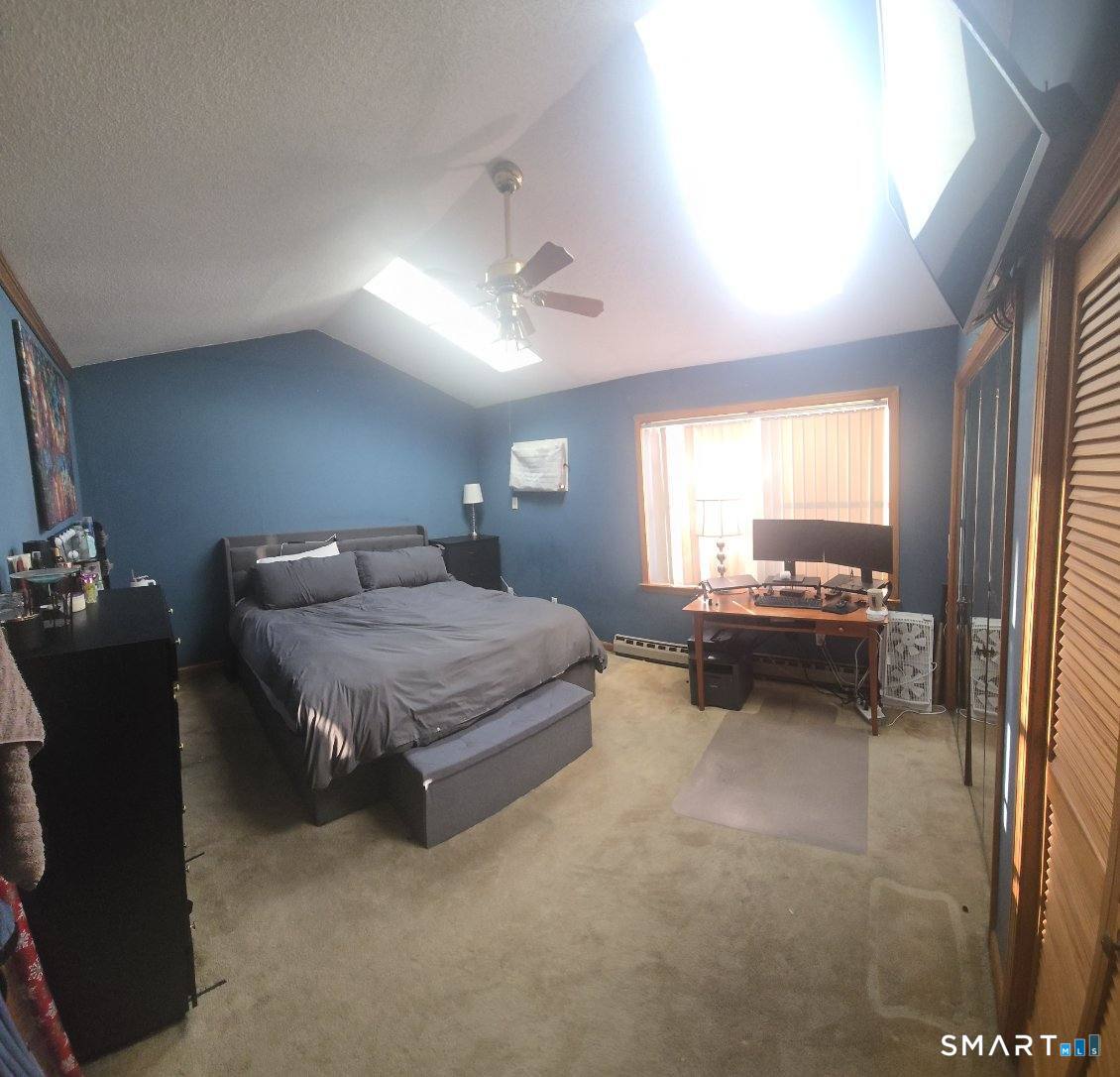 40 South Street, Unit 25 Bristol, CT 06010 - Photo 8 of 24 a spacious bedroom with a bed and a chandelier