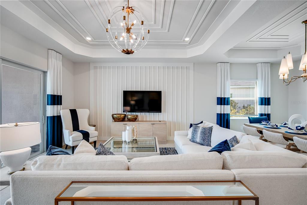 7165 Inlet Isles Lakewood Ranch, FL 34202 - Photo 4 of 26 a living room with furniture a flat screen tv and a chandelier