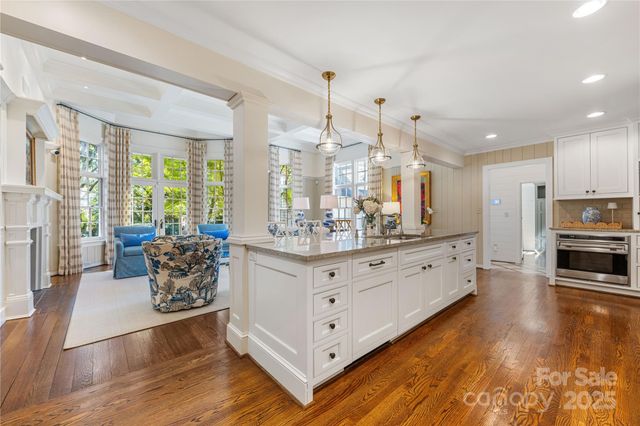 a living room with furniture large window and wooden floor