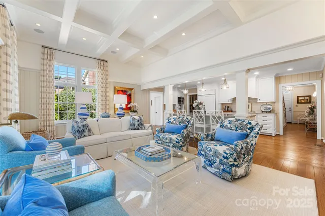 a living room with furniture kitchen view and a large window
