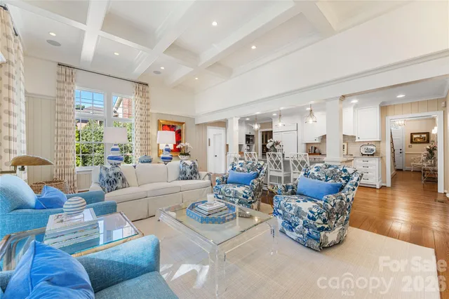 a living room with furniture kitchen view and a large window
