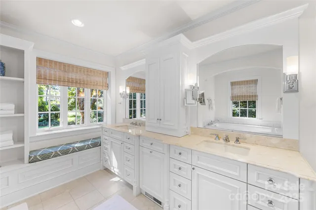 a spacious bathroom with double vanity and a large mirror
