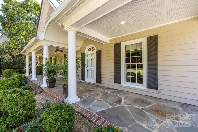 front view of a house with a large window and potted plants