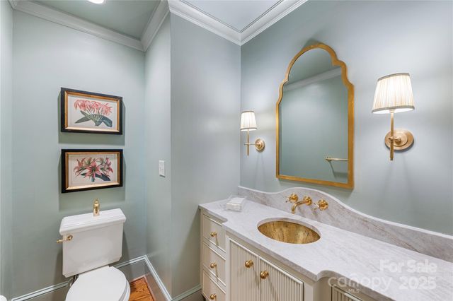 a bathroom with a toilet sink vanity mirror and vanity