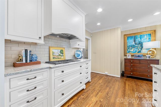 a kitchen with granite countertop white cabinets and white appliances