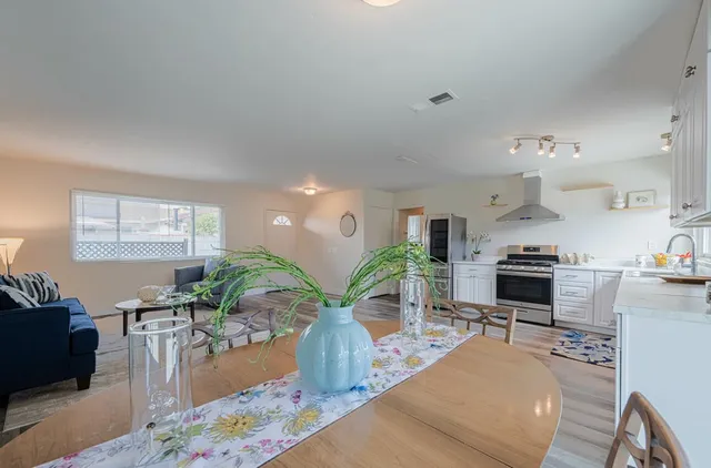 a living room with furniture kitchen view and a window