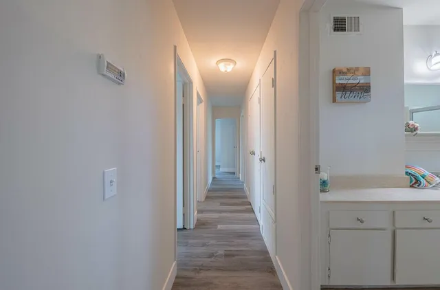 a view of a hallway with wooden floor