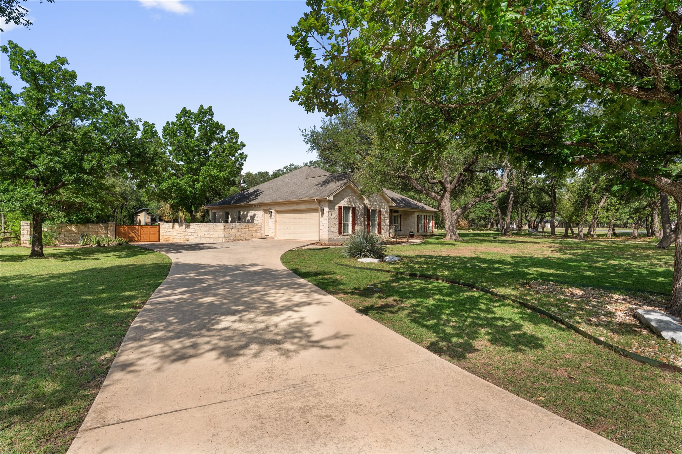 223 East Ridgewood Road Georgetown, TX 78633 - Photo 4 of 40 A graceful driveway leads to a single-story home nestled among mature trees for added privacy