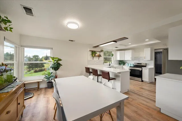 a living room with stainless steel appliances kitchen island furniture and a large window