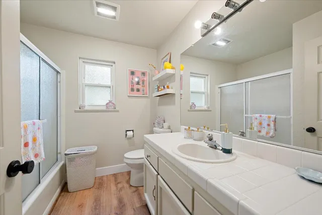 a bathroom with a sink toilet vanity and shower
