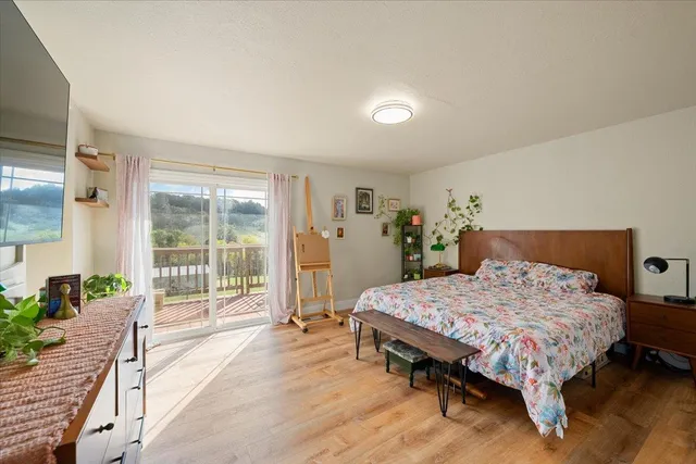 a bed sitting in a spacious bedroom next to a window