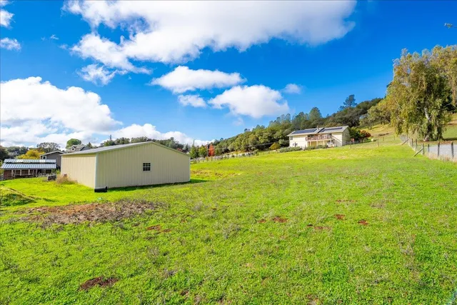 a view of a big yard with an outdoor and a car parked