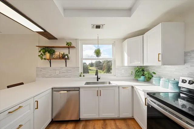 a kitchen with white cabinets and appliances