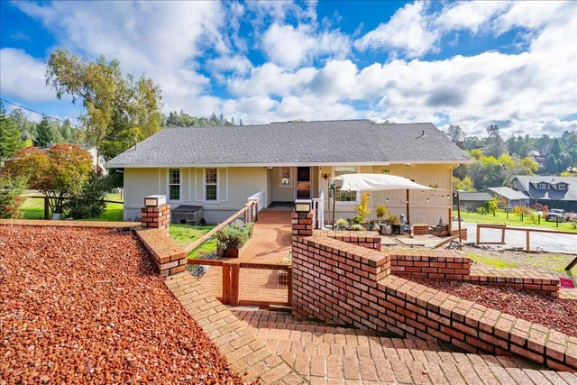 a view of a patio with couches table and chairs under an umbrella