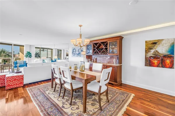 a dining room with furniture a chandelier and wooden floor