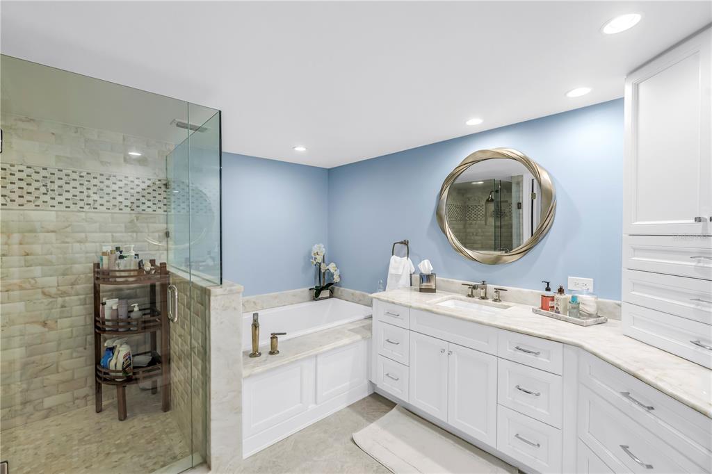 6650 Sunset Way, Unit 207 St. Pete Beach, FL 33706 - Photo 29 of 57 a en suite bathroom with a double vanity sink a mirror and a mirror