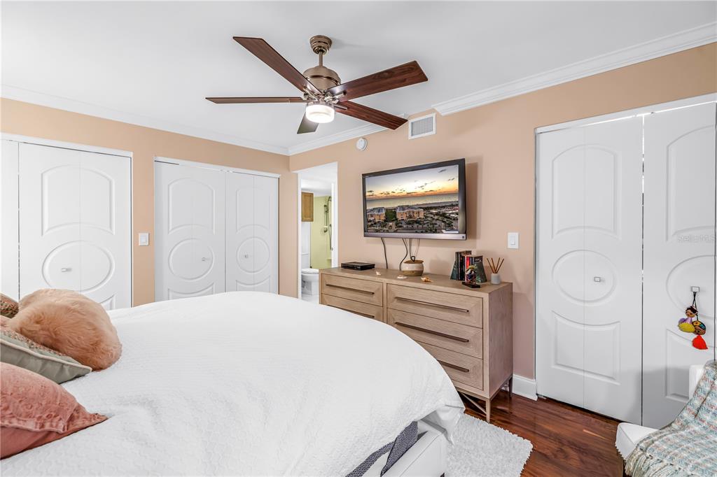 6650 Sunset Way, Unit 207 St. Pete Beach, FL 33706 - Photo 34 of 57 a bedroom with a large bed and a chandelier