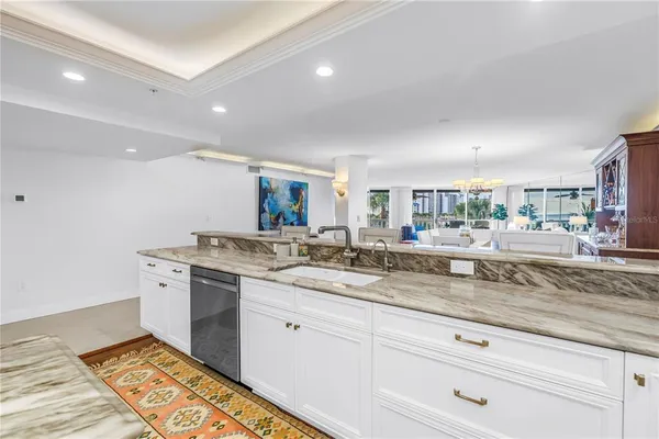 a kitchen with granite countertop white cabinets and white appliances