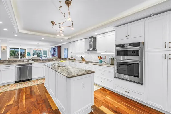 a kitchen with stainless steel appliances granite countertop a refrigerator and a stove top oven