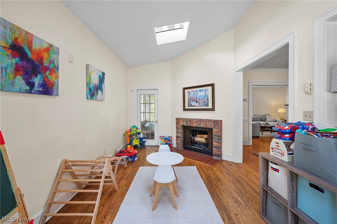 2941 Coleridge Road Cleveland, OH 44118 - Photo 11 of 42 Sitting room featuring a fireplace, wood-type flooring, and vaulted ceiling with skylight