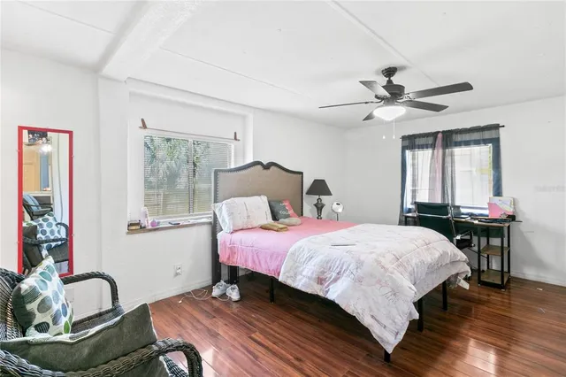 a bedroom with a bed a dresser and a window