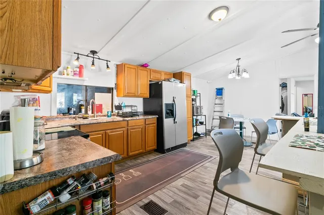 a kitchen with stainless steel appliances kitchen island granite countertop a table chairs in it and a window