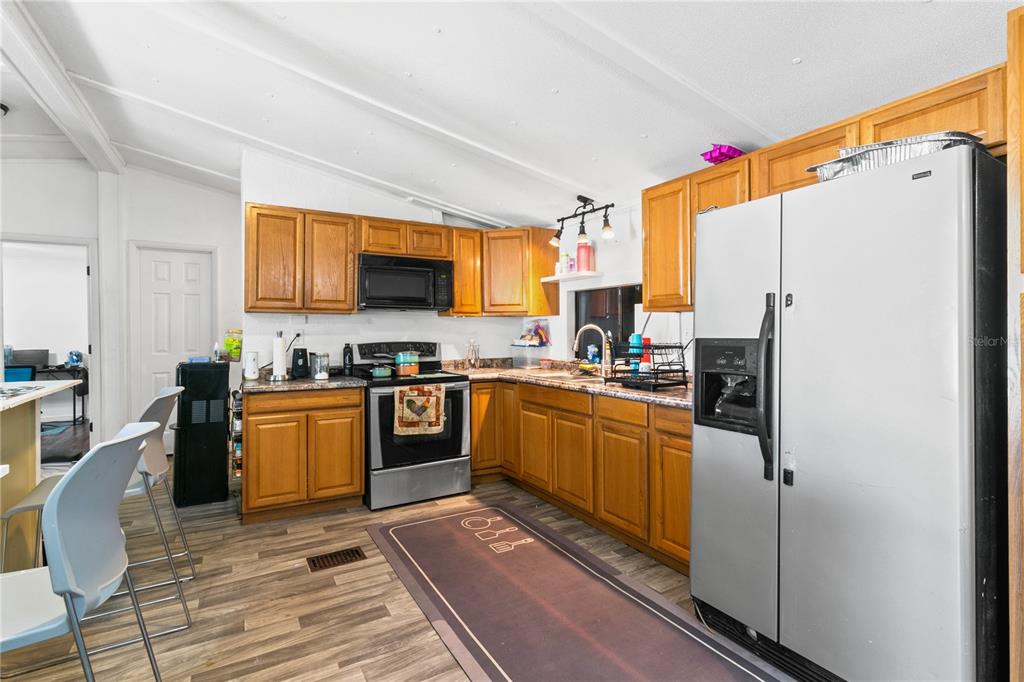 18312 16th Avenue Orlando, FL 32833 - Photo 4 of 26 a kitchen with stainless steel appliances granite countertop a refrigerator sink and stove