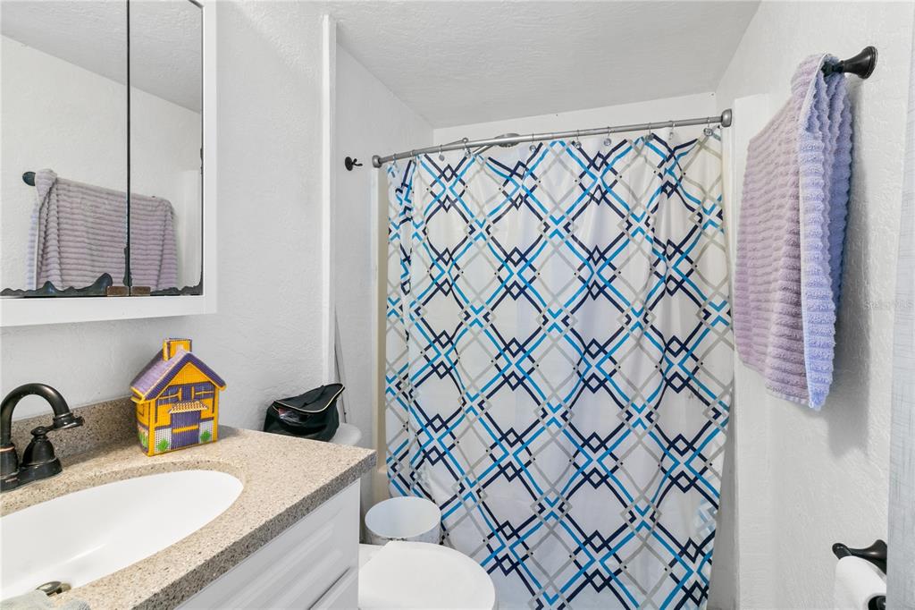 18312 16th Avenue Orlando, FL 32833 - Photo 10 of 26 a bathroom with a granite countertop sink and a mirror with shower curtain