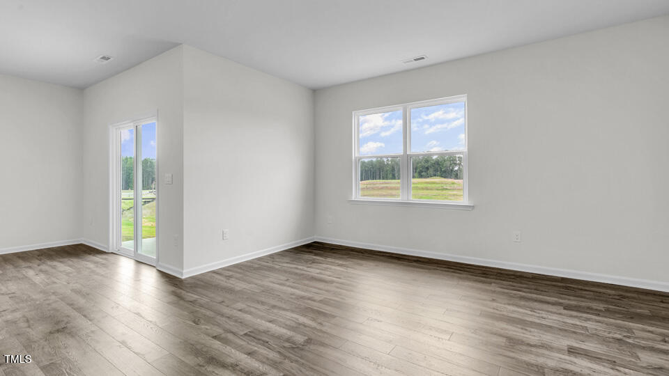 905 Comice Pear Way Willow Spring, NC 27592 - Photo 13 of 33 an empty room with wooden floor and windows