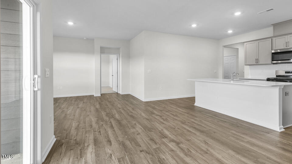 905 Comice Pear Way Willow Spring, NC 27592 - Photo 7 of 33 a view of a kitchen with a sink and wooden floor