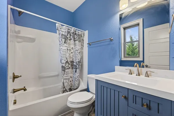 a bathroom with a granite countertop sink two mirror and a shower