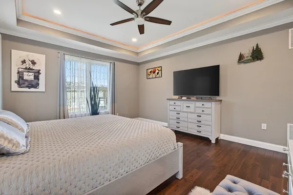 an empty room with wooden floor and a ceiling fan