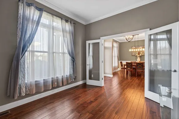 a dining room with wooden floor and a large window