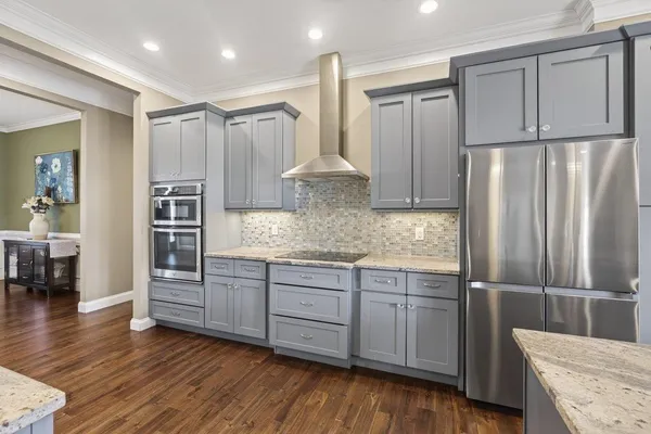 a kitchen with stainless steel appliances granite countertop a refrigerator and a stove top oven