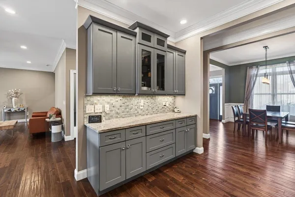 a large kitchen with stainless steel appliances wooden floors and living room view