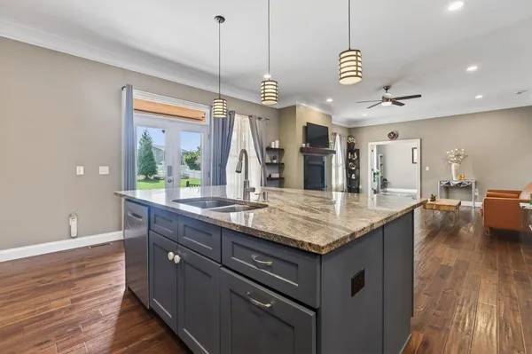 a kitchen with granite countertop a table chairs and wooden floor