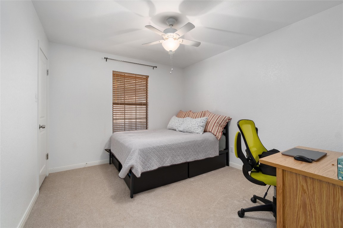 2317 Sycamore Trail Round Rock, TX 78664 - Photo 21 of 31 a bedroom with a bed a chandelier and dresser
