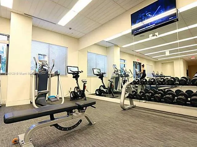 a kitchen with stainless steel appliances kitchen island granite countertop a stove and white cabinets