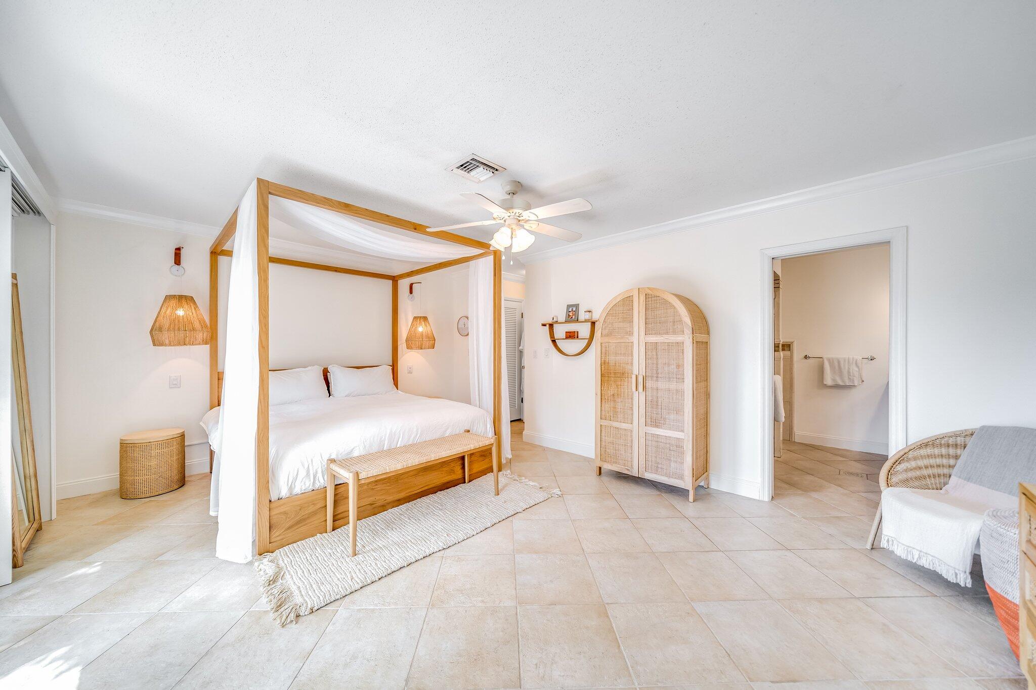 4010 Northeast 25th Avenue Lighthouse Point, FL 33064 - Photo 15 of 57 a spacious bedroom with a large bed a ceiling fan and a rug