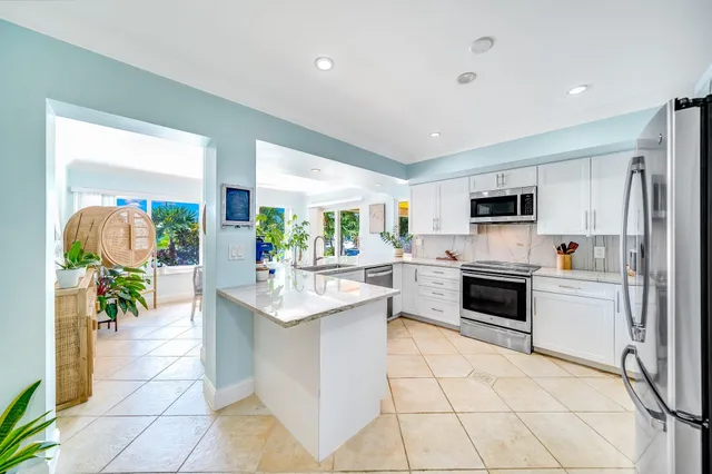 a kitchen with white cabinets stainless steel appliances and a window