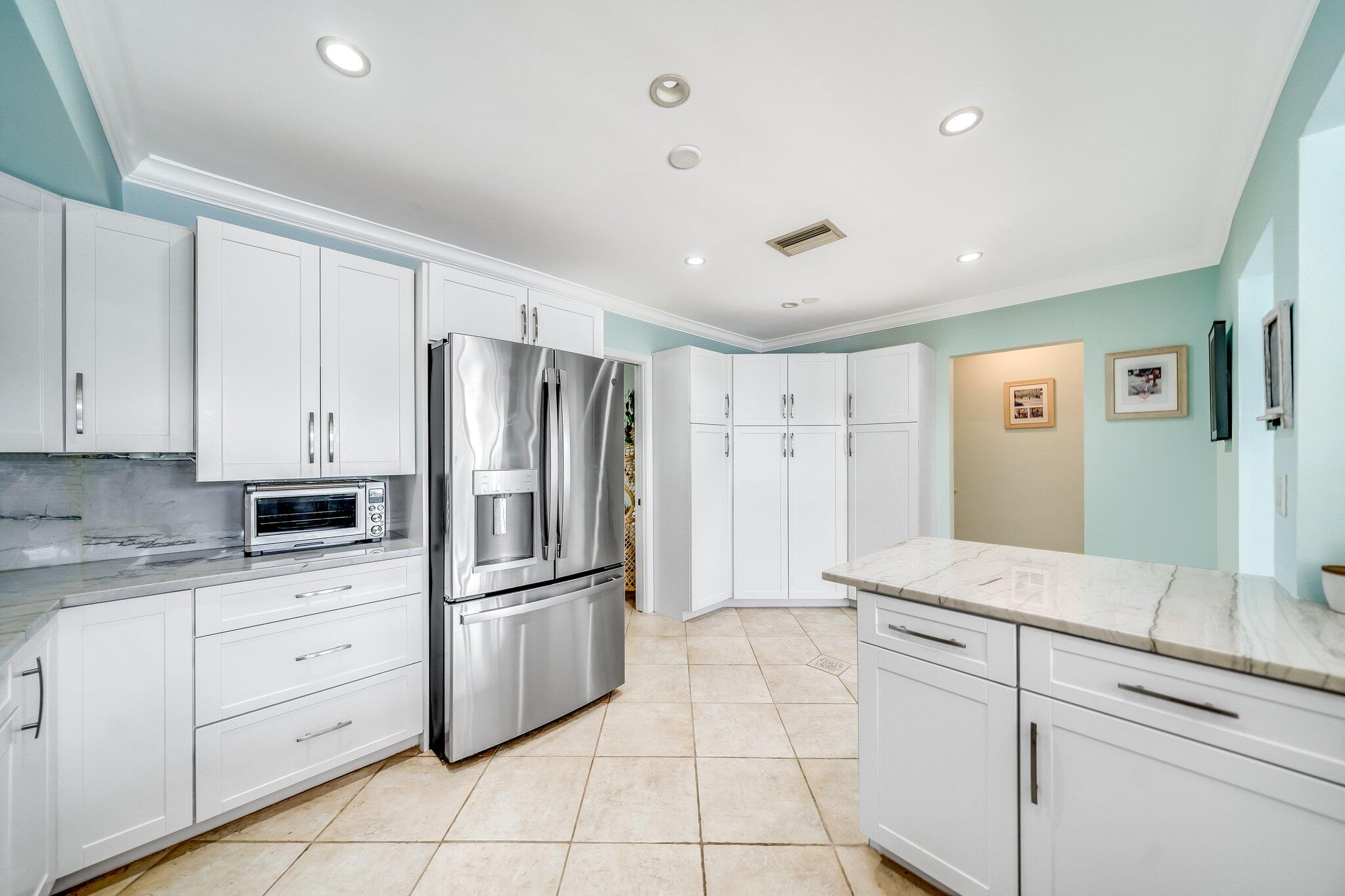 4010 Northeast 25th Avenue Lighthouse Point, FL 33064 - Photo 23 of 57 a kitchen with white cabinets stainless steel appliances and a window