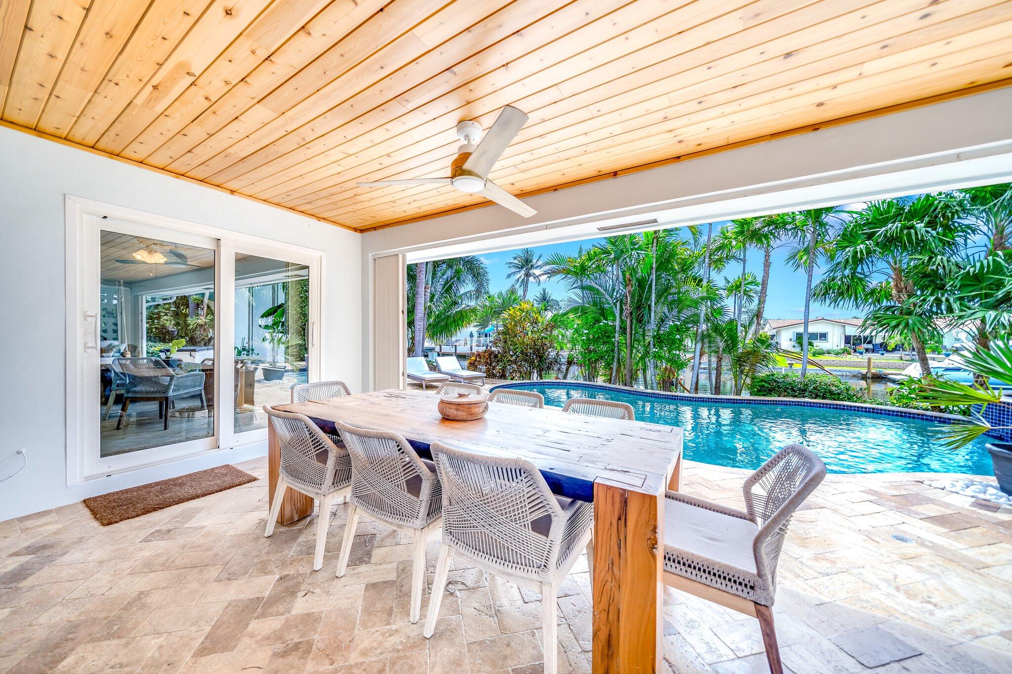 4010 Northeast 25th Avenue Lighthouse Point, FL 33064 - Photo 31 of 57 a view of a patio with a table chairs and a backyard
